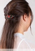 Flexi hair clip with mushroom with a bright red cap and matching beads in brown hair