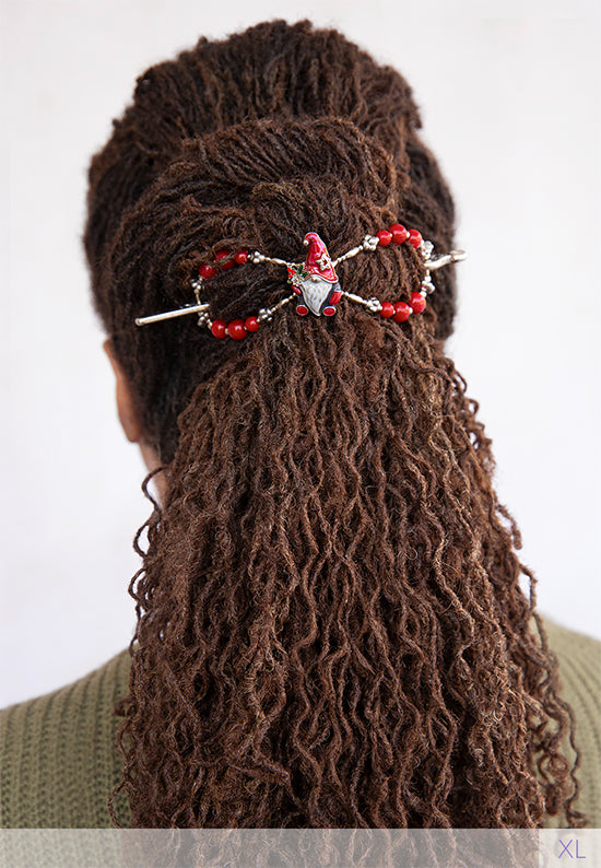 Flexi clip with christmas gnome with a long white beard and bright red hat holds a bundle of holly in brown locs