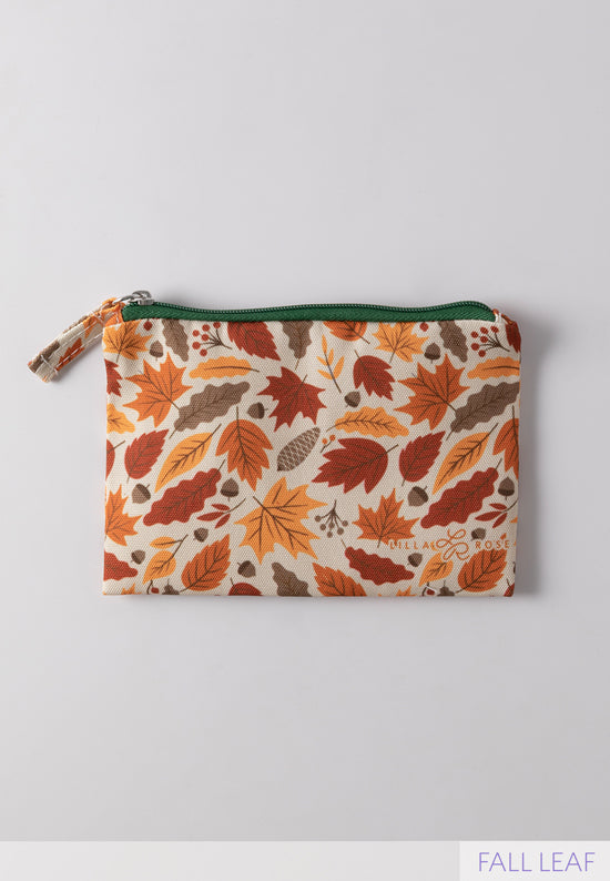 fall leaf printed Lilla Rose zipper pouch in burnt orange colors, yellow, and light brown with a green zipper 